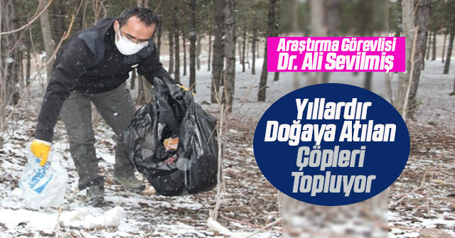 Araştırma görevlisi doğaya atılan çöpleri topluyor.